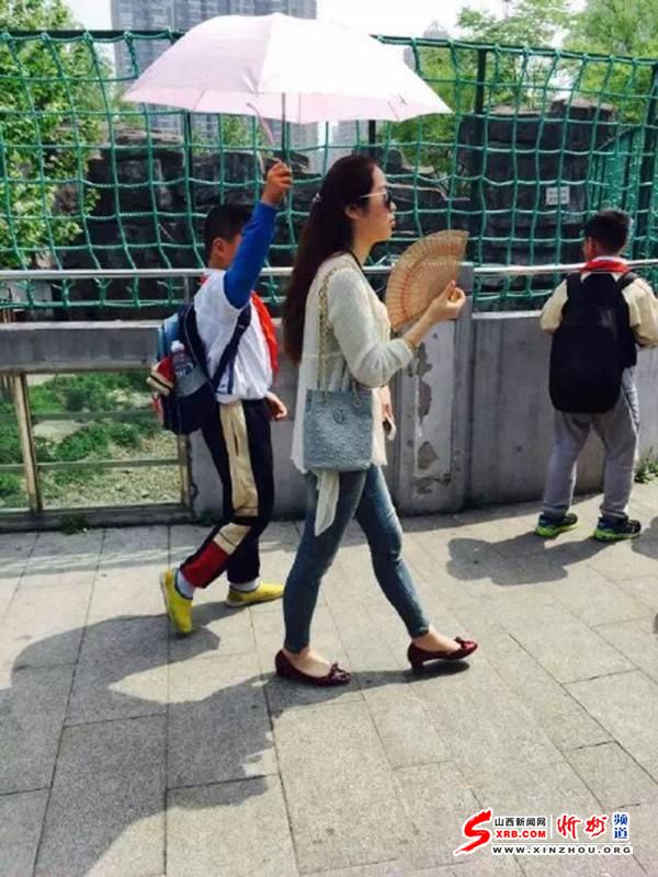 网传小学生为女教师打伞遮阳 女子表情霸气