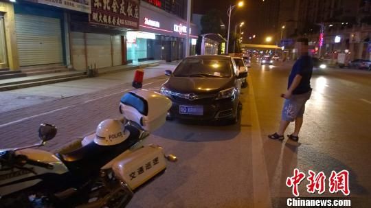 6月4日晚，南宁青林路一辆私家车被协警“贴单”，其前后是开来吃宵夜的警车。 王刚 摄