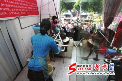 邹属民发明的机器人在餐厅内推石磨豆花迎来市民围观